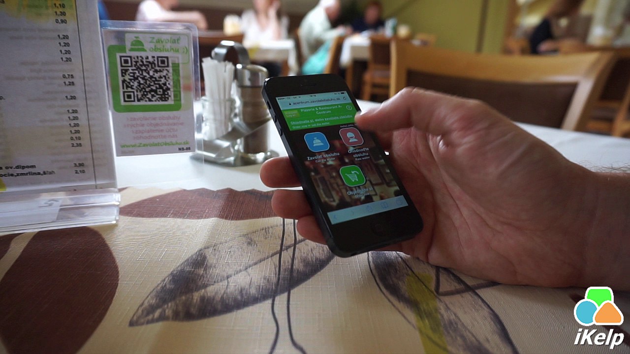 Hosť skenuje QR k&oacute;d na stole, na obrazovke telef&oacute;nu sa zobrazuje menu s možnosťami Zavolať obsluhu, Hodnotiť obsluhu a Objedn&aacute;vka