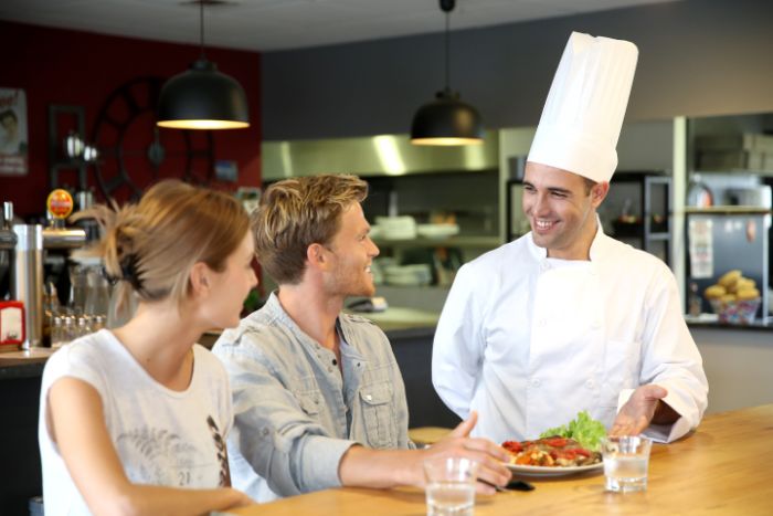 Šéfkuchár komunikujúci s hosťami reštaurácie