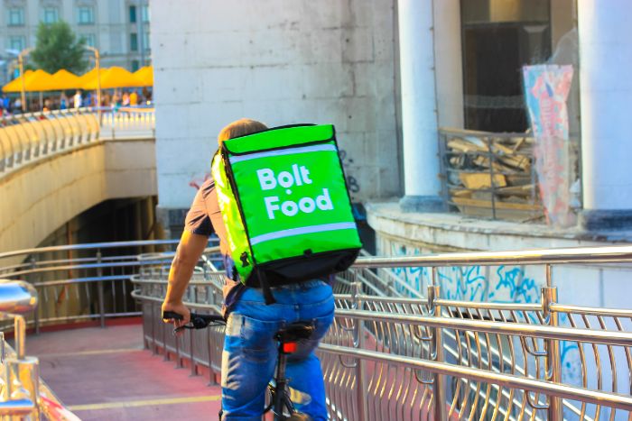 kuriér z firmy Bolt Food doručuje objednané jedlo